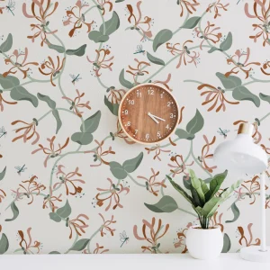 Honeysuckle floral wallpaper in terracotta, blush and sage tones with wooden clock and potted plant – modern botanical interior from the Flow Collection by Eldy Pattern Design.